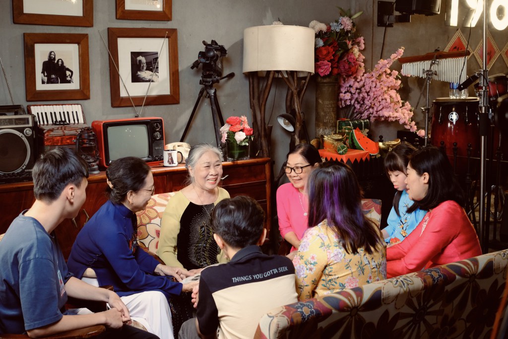Three generations of a family gathered in a living room, listening to their grandmother